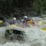 Ludzie na pontonie walczą z rwącym nurtem rzeki. To jest właśnie rafting – emocjonująca przygoda na wodzie!