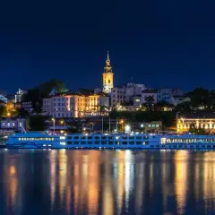 Nocny Belgrad z rzeką i statkiem wycieczkowym. Czy do Serbii potrzebny jest paszport? Sprawdź przed podróżą!