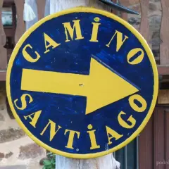 Żółta strzałka na niebieskim tle, z napisem "Camino Santiago", wskazuje drogę na szlak św. Jakuba.