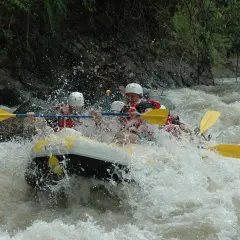 Ludzie na pontonie walczą z rwącym nurtem rzeki. To jest właśnie rafting – emocjonująca przygoda na wodzie!