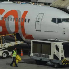 Samolot Boeing 737 MAX 8 linii GOL na lotnisku. Pracownik obsługi naziemnej niesie żółty worek.