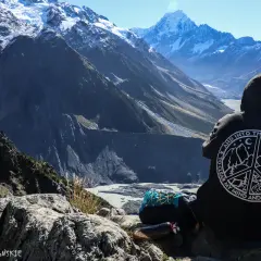Osoba w bluzie z napisem "Into the Wild" patrzy na najwyższy szczyt Nowej Zelandii, Aoraki/Mount Cook.