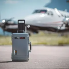 Szara walizka Peli Air na lotnisku, gotowa na lot czarterowy.