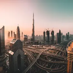 Zachód słońca nad Dubajem, z drapaczami chmur i skomplikowanymi autostradami. Czy w Dubaju jest bezpiecznie? Tak, to nowoczesne miasto oferuje spokój.