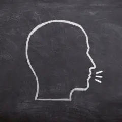 Kreda na tablicy rysuje profil głowy z otwartymi ustami, jakby mówił "dzień dobry po turecku".