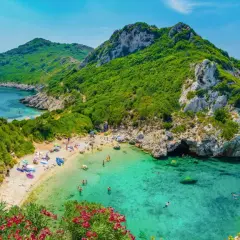 Malownicza zatoka z turkusową wodą, piaszczystą plażą i zielonymi wzgórzami. Idealne miejsce na wakacje na jednych z najpiękniejszych wysp w Europie.