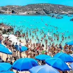 Tłum ludzi na plaży i w turkusowej wodzie. Wiele łodzi na morzu. Czy na Malcie jest bezpiecznie? Tak, wygląda na to, że turyści czują się swobodnie.