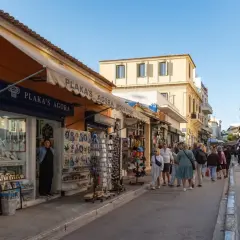 Spacerem po Plaka w Atenach, gdzie turyści kupują pamiątki. Czy w Grecji jest bezpiecznie? Tak, to popularne i bezpieczne miejsce.