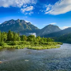 Malowniczy widok na Dunajec w Pieninach, gdzie góry i lasy otaczają rzekę. To piękno, które można podziwiać, zapominając o zgiełku miast w Polsce.