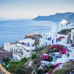 Santorini, Grecja. Czy do Grecji potrzebny jest paszport? Tak, jeśli nie jesteś obywatelem UE. Białe domy, niebieskie drzwi, morze.