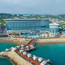 Luksusowy hotel z basenami i plażą w Okurcalar. Widok z lotu ptaka na hotel, molo i morze.