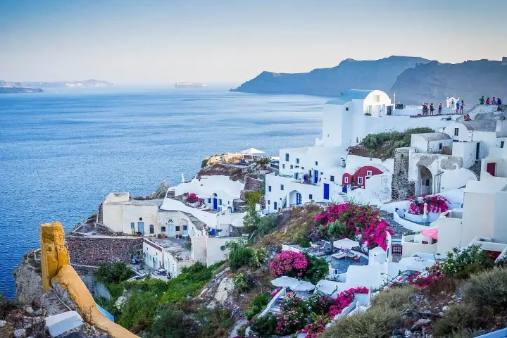 Santorini, Grecja. Czy do Grecji potrzebny jest paszport? Tak, jeśli nie jesteś obywatelem UE. Białe domy, niebieskie drzwi, morze.
