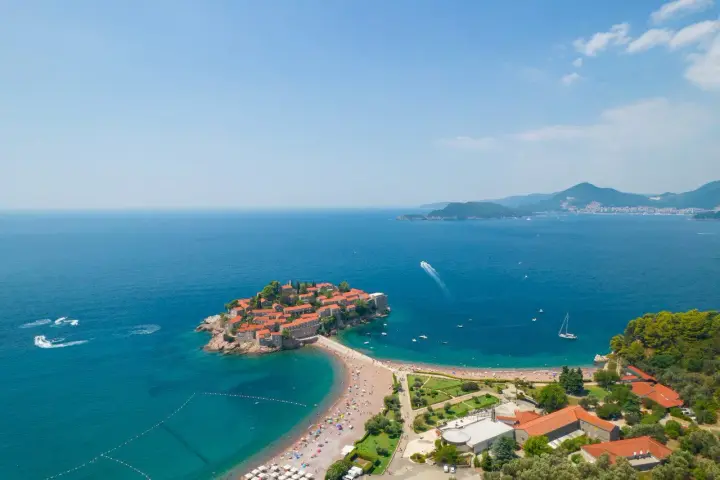 Wyspa Sveti Stefan, perła Czarnogóry, idealne miejsce na wakacje. Błękitne morze, piaszczysta plaża i urokliwe miasteczko.