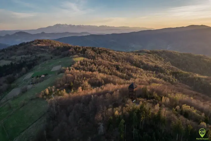Wieża widokowa na tle zachodzącego słońca w Beskidzie Sądeckim. W oddali majaczą Tatry.