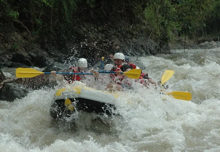 Ludzie na pontonie walczą z rwącym nurtem rzeki. To jest właśnie rafting – emocjonująca przygoda na wodzie!