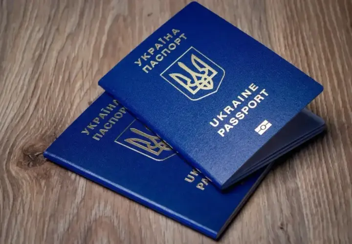 Dwa niebieskie paszporty Ukrainy leżą na drewnianym blacie. Czy do Turcji potrzebny jest paszport? Tak, ten dokument jest niezbędny.