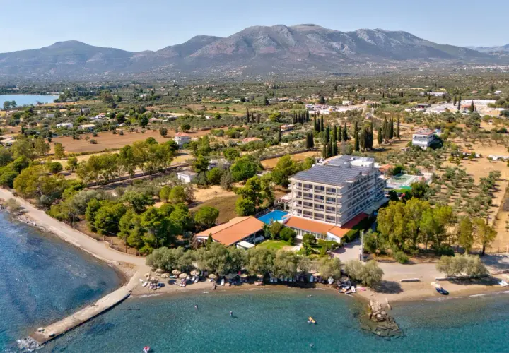 Hotel z panelami słonecznymi nad morzem, z plażą i górami w tle. Wakacje na wyspie Evia.