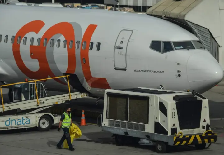 Samolot Boeing 737 MAX 8 linii GOL na lotnisku. Pracownik obsługi naziemnej niesie żółty worek.