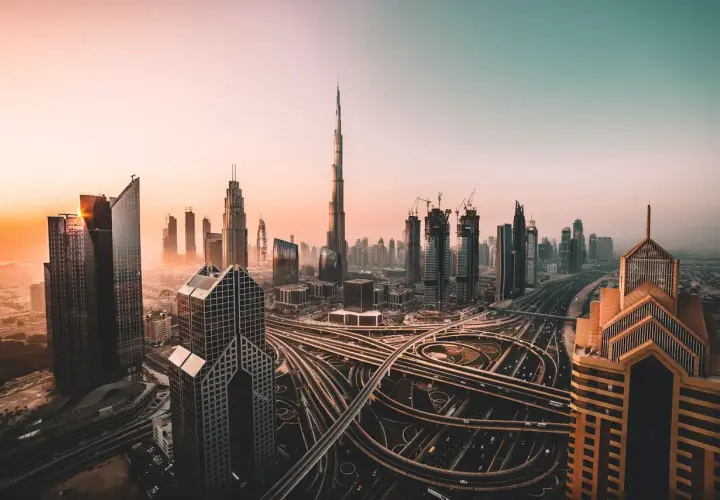 Zachód słońca nad Dubajem, z drapaczami chmur i skomplikowanymi autostradami. Czy w Dubaju jest bezpiecznie? Tak, to nowoczesne miasto oferuje spokój.