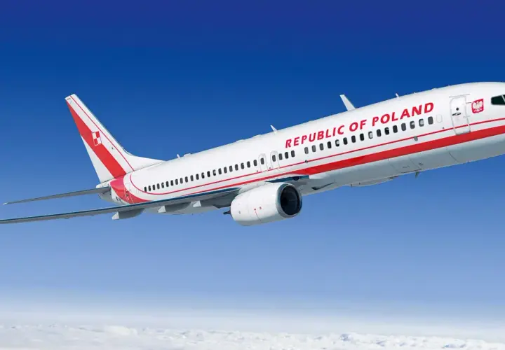 Biało-czerwony boeing 737 z napisem "REPUBLIC OF POLAND" na tle błękitnego nieba i chmur.