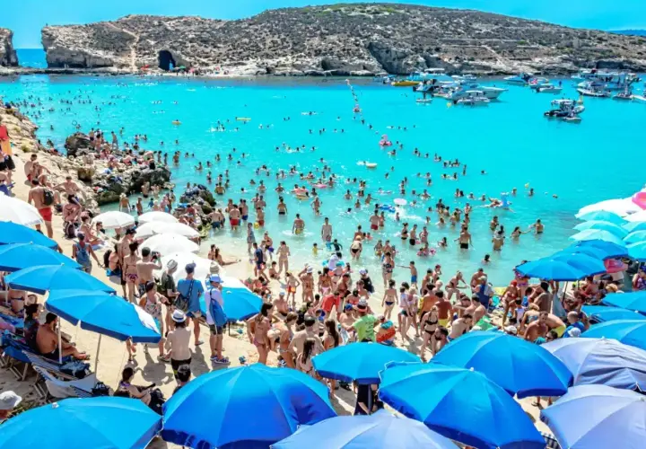Tłum ludzi na plaży i w turkusowej wodzie. Wiele łodzi na morzu. Czy na Malcie jest bezpiecznie? Tak, wygląda na to, że turyści czują się swobodnie.