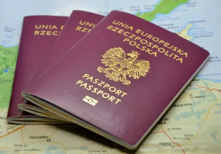 Trzy polskie paszporty leżą na mapie. Zastanawiasz się, ile się czeka na paszport, by wyruszyć w podróż?