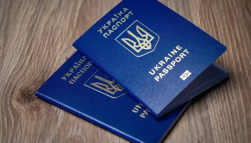 Dwa niebieskie paszporty Ukrainy leżą na drewnianym blacie. Czy wystarczy paszport, czy potrzebny jest dowód na wyjazd do Turcji?
