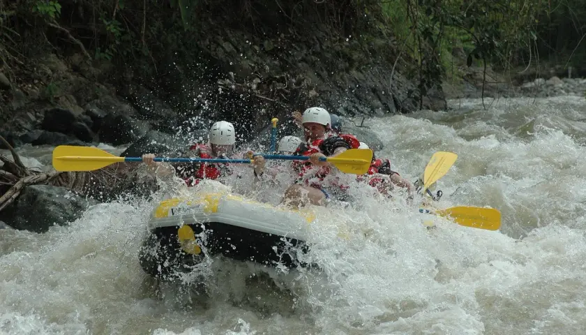 Ludzie na pontonie walczą z rwącym nurtem rzeki. To jest właśnie rafting – emocjonująca przygoda na wodzie!