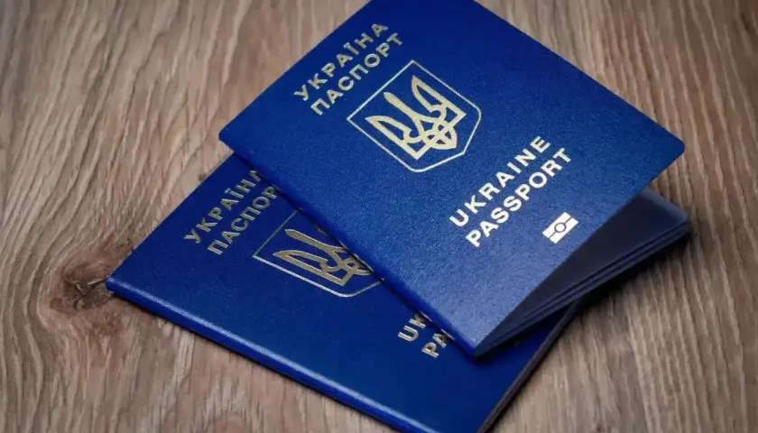 Dwa niebieskie paszporty Ukrainy leżą na drewnianym blacie. Czy do Turcji potrzebny jest paszport? Tak, ten dokument jest niezbędny.