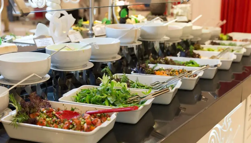 Bufet z sałatkami i sosami, idealny na pełne menu plus. Świeże warzywa i zioła kuszą, by skomponować własną, zdrową porcję.