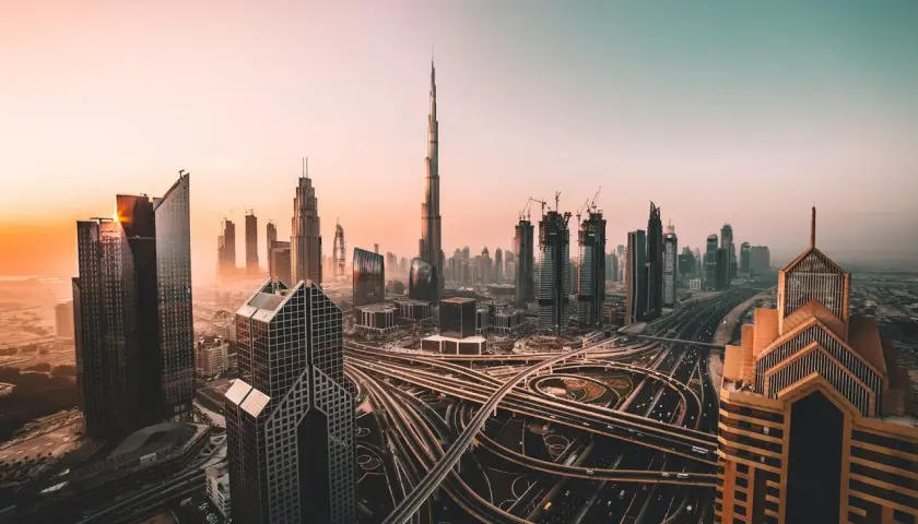 Zachód słońca nad Dubajem, z drapaczami chmur i skomplikowanymi autostradami. Czy w Dubaju jest bezpiecznie? Tak, to nowoczesne miasto oferuje spokój.