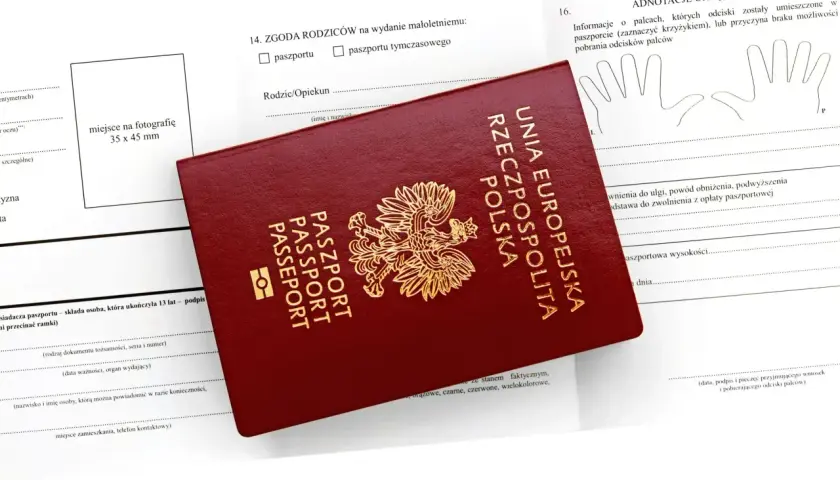 Czerwony paszport Rzeczypospolitej Polskiej leży na formularzu wniosku. Możliwość złożenia wniosku o paszport online ułatwia ten proces.