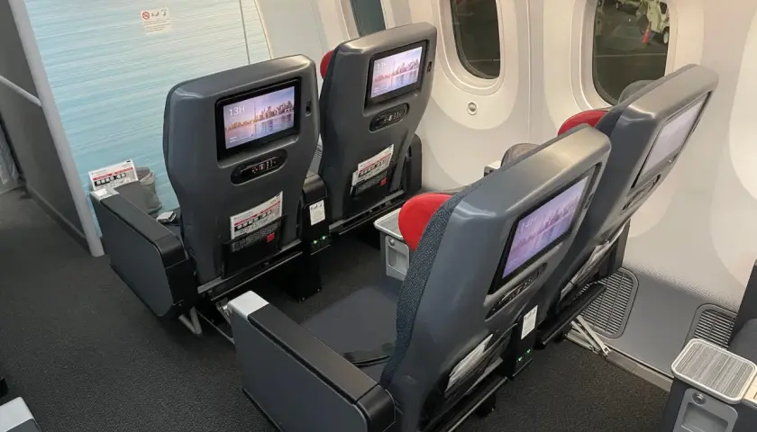 Dreamliner lot klasa ekonomiczna. Siedzenia w samolocie z ekranami rozrywki pokładowej, gotowe na podróż.