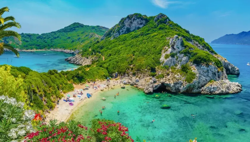 Malownicza zatoka z turkusową wodą, piaszczystą plażą i zielonymi wzgórzami. Idealne miejsce na wakacje na jednych z najpiękniejszych wysp w Europie.