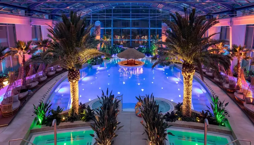 Tropikalny raj w hotelu 5 gwiazdkowym: basen z podświetlanym barem, palmy i jacuzzi.