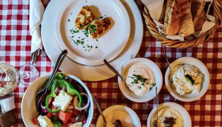 Pyszne jedzenie z Cypru: sałatka grecka, halloumi, pieczywo i dipy. Idealny posiłek na wakacjach.