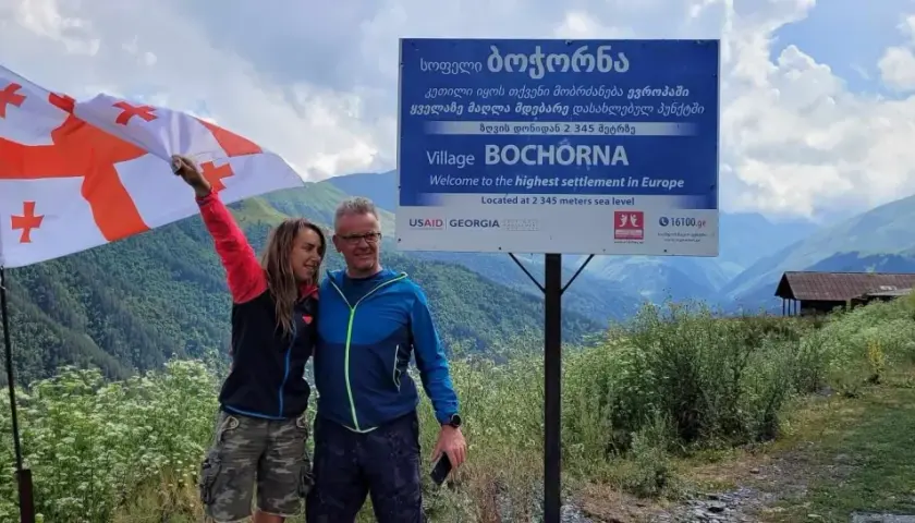 Para podróżników z flagą Gruzji w Bochorna, najwyżej położonej osadzie w Europie. Odpowiedź na pytanie: czy w Gruzji jest bezpiecznie? Tak!