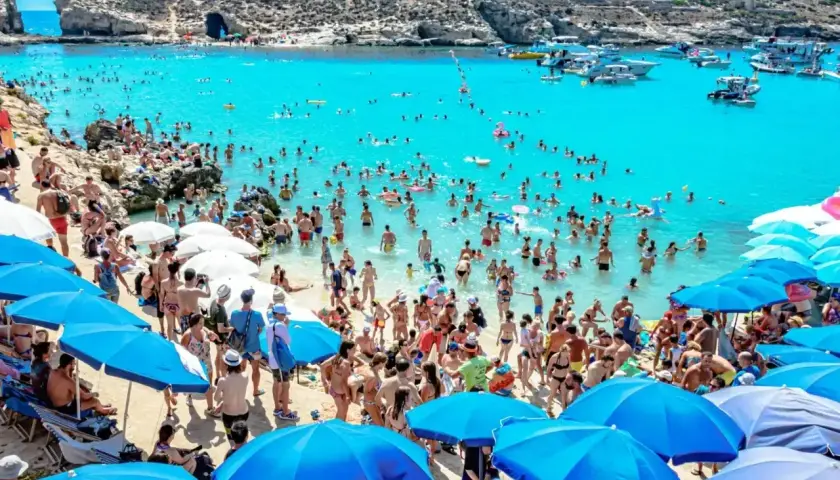 Tłum ludzi na plaży i w turkusowej wodzie. Wiele łodzi na morzu. Czy na Malcie jest bezpiecznie? Tak, wygląda na to, że turyści czują się swobodnie.