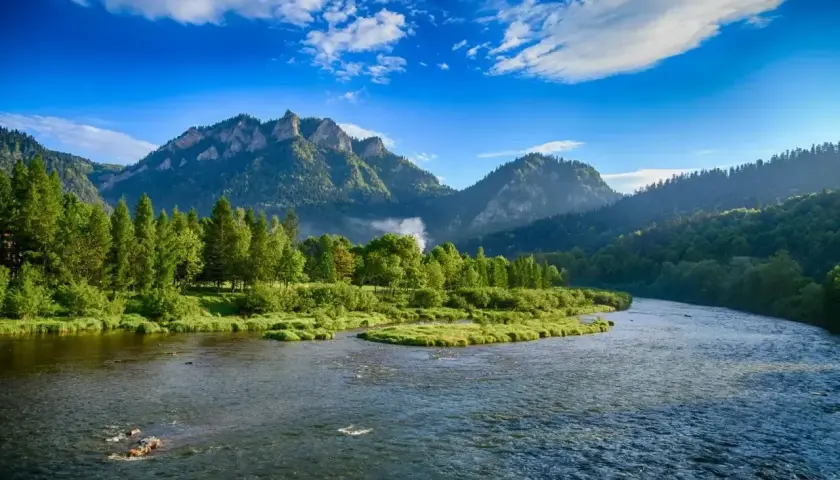 Malowniczy widok na Dunajec w Pieninach, gdzie góry i lasy otaczają rzekę. To piękno, które można podziwiać, zapominając o zgiełku miast w Polsce.