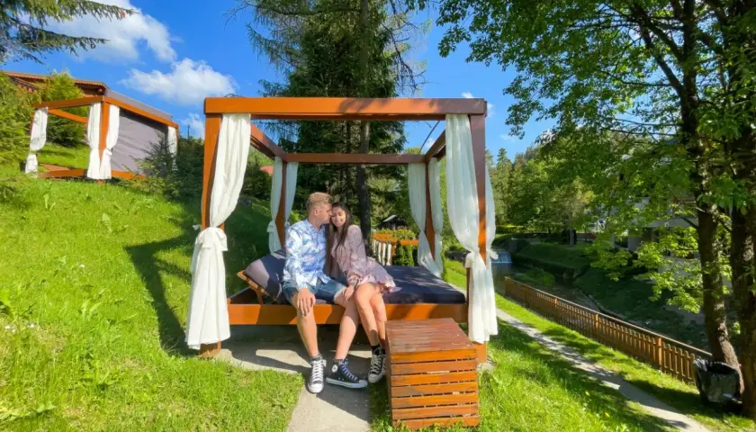 Para na łóżku pod baldachimem, idealne miejsce, gdzie pojechać na weekend.