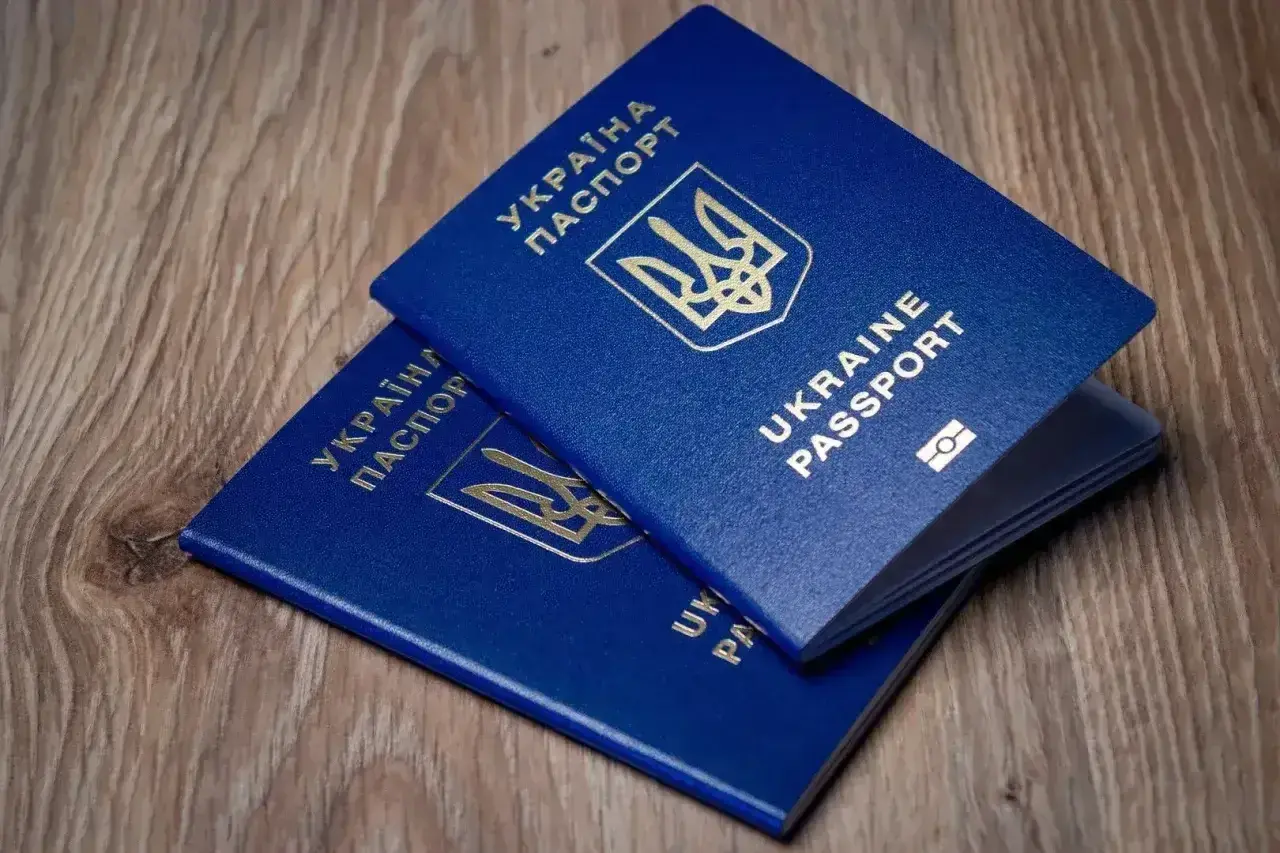 Dwa niebieskie paszporty Ukrainy leżą na drewnianym blacie. Czy do Turcji potrzebny jest paszport? Tak, ten dokument jest niezbędny.