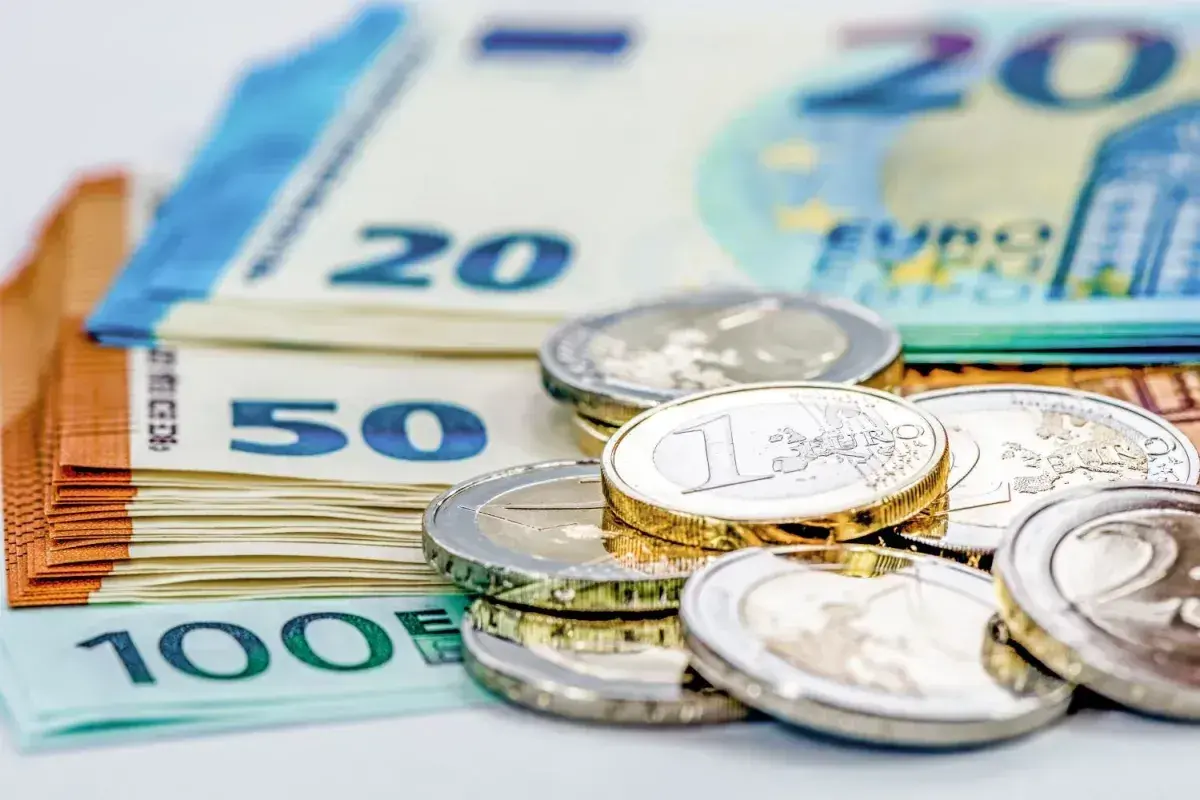 Stos banknotów euro (20, 50, 100) i monet. Zastanawiasz się, ile euro można przewieźć przez granicę na osobę?