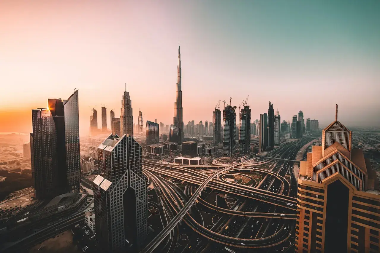 Zachód słońca nad Dubajem, z drapaczami chmur i skomplikowanymi autostradami. Czy w Dubaju jest bezpiecznie? Tak, to nowoczesne miasto oferuje spokój.