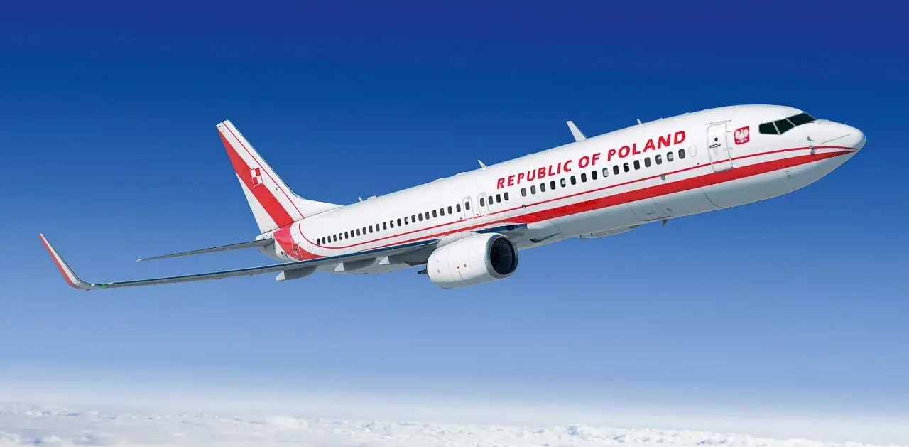 Biało-czerwony boeing 737 z napisem "REPUBLIC OF POLAND" na tle błękitnego nieba i chmur.