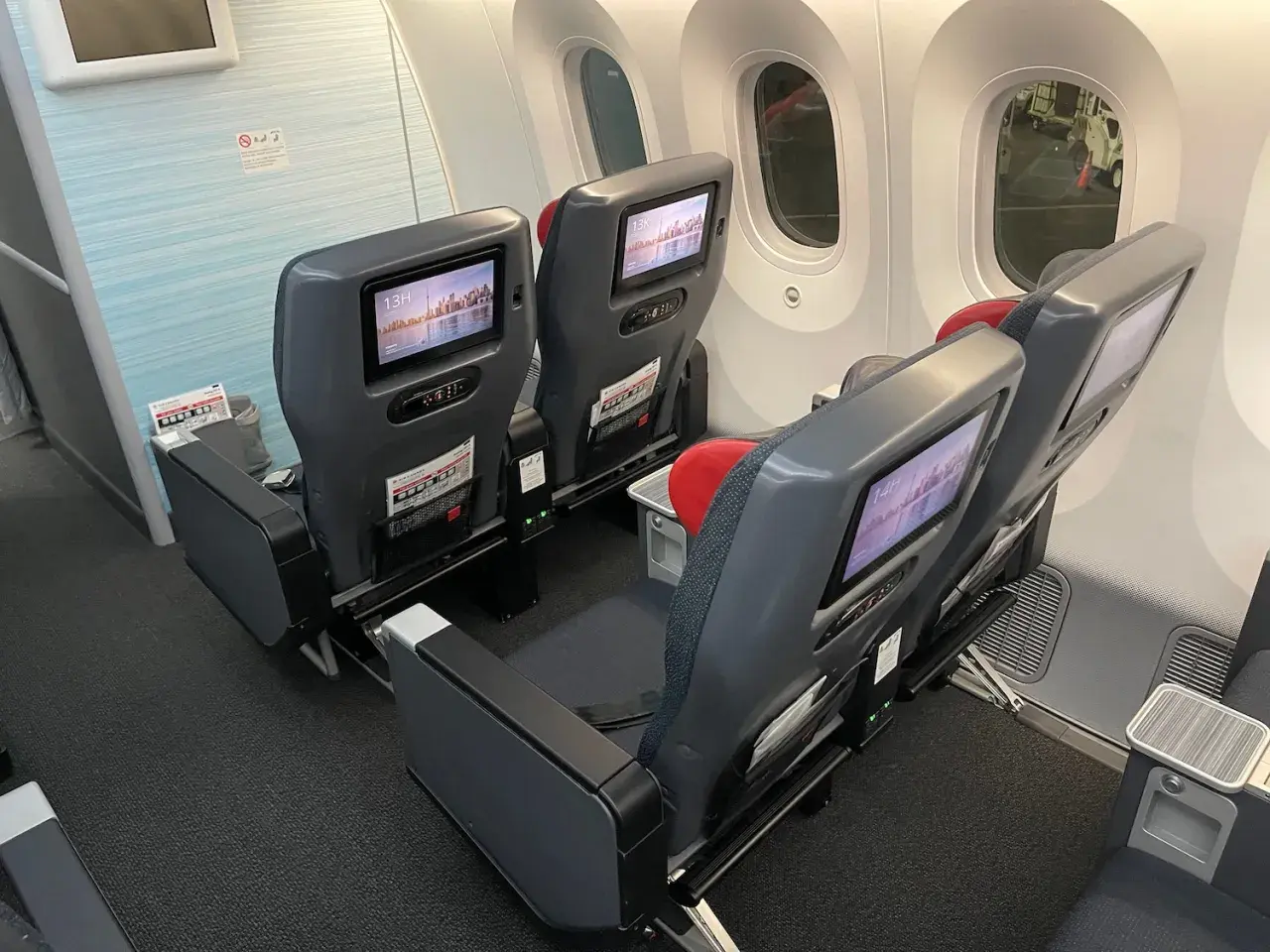 Dreamliner lot klasa ekonomiczna. Siedzenia w samolocie z ekranami rozrywki pokładowej, gotowe na podróż.