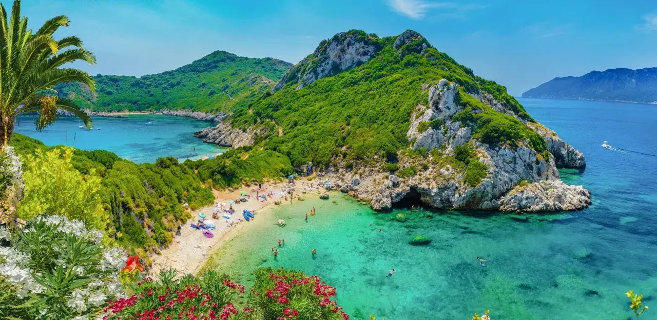 Malownicza zatoka z turkusową wodą, piaszczystą plażą i zielonymi wzgórzami. Idealne miejsce na wakacje na jednych z najpiękniejszych wysp w Europie.