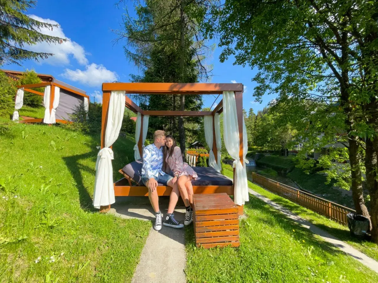 Para na łóżku pod baldachimem, idealne miejsce, gdzie pojechać na weekend.