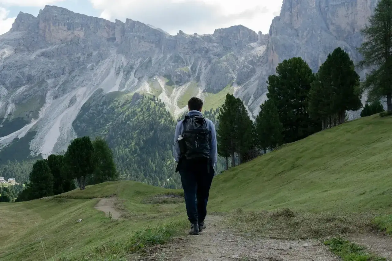 Wędrowiec z plecakiem na tle gór w Val Gardena.