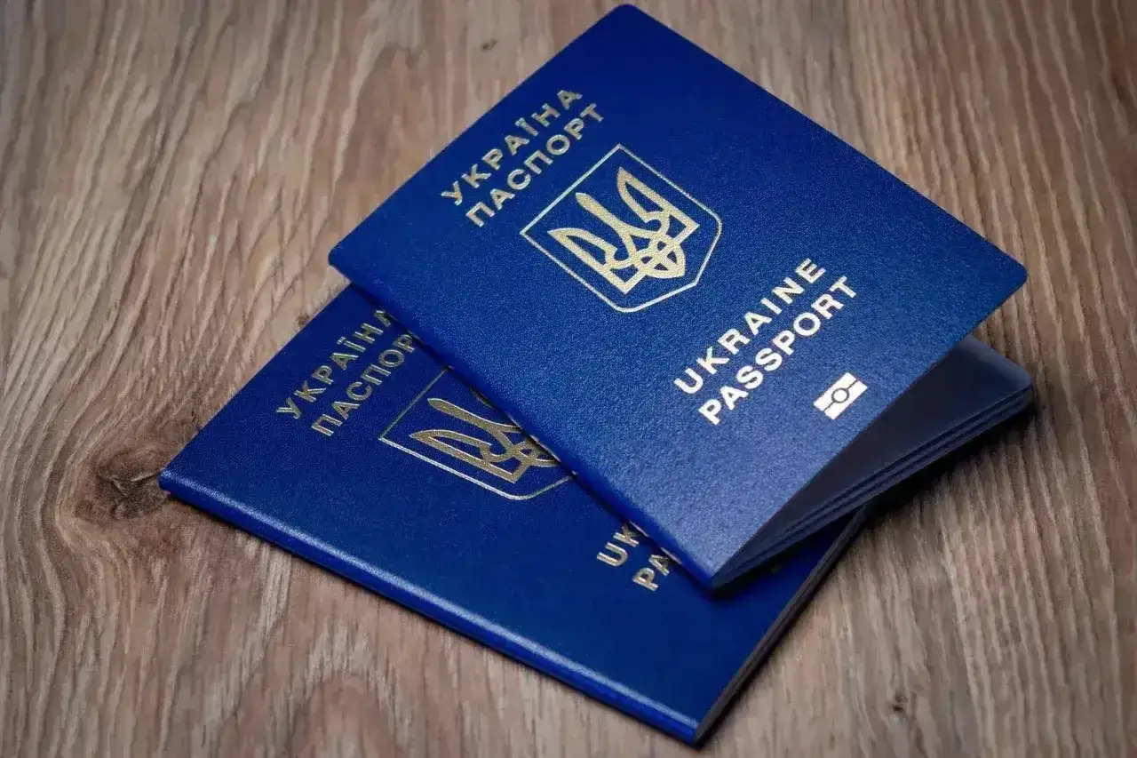 Dwa niebieskie paszporty Ukrainy leżą na drewnianym stole. Czy to wystarczy na wyjazd do Turcji, paszport czy dowód?