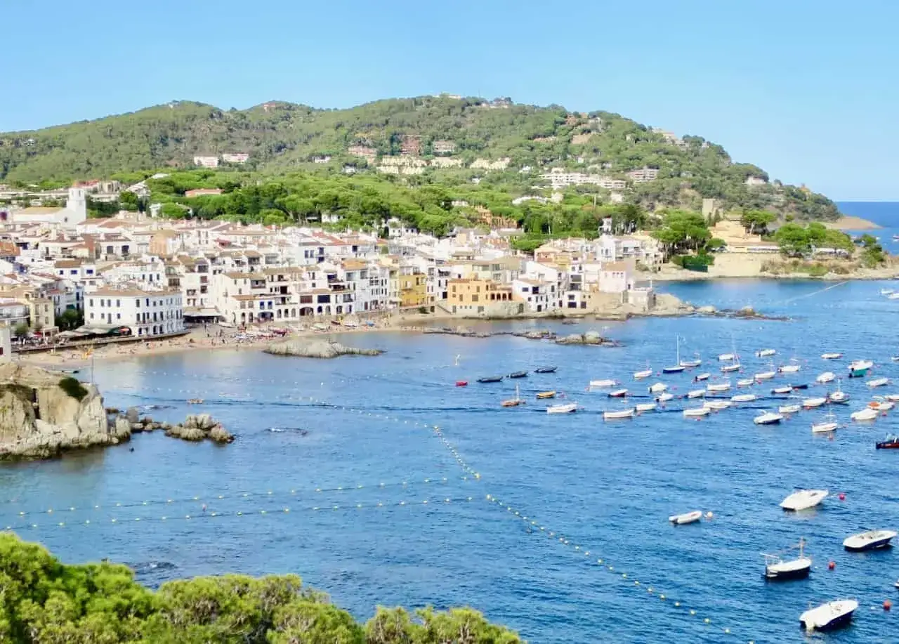 Malownicze białe domki nad zatoką, mnóstwo łodzi na lazurowej wodzie. Idealne miejsce na costa brava wakacje.